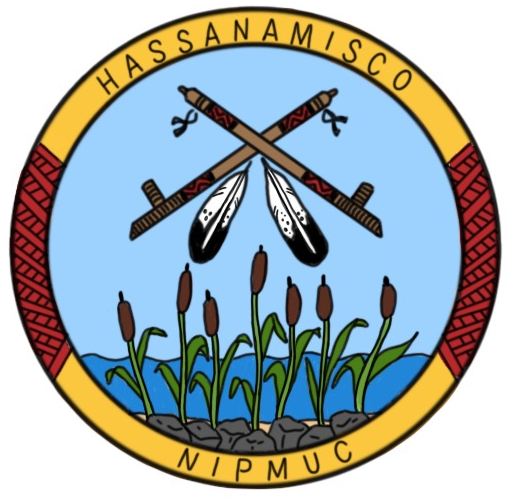 http://The%20Hassanamisco%20Nipmuc%20Band%20seal,%20featuring%20a%20central%20design%20of%20crossed%20peace%20pipes,%20each%20decorated%20with%20an%20eagle%20feather%20and%20leather,%20behind%20is%20a%20clear%20blue%20sky%20with%20seven%20cattails%20below%20growing%20upwards%20from%20small%20stones%20in%20the%20water%20below,%20encircled%20by%20a%20ring%20with%20the%20words%20“Hassanamisco”%20and%20“Nipmuc”%20in%20black%20over%20a%20yellow%20background,%20with%20red%20weaving%20between%20the%20two%20words.